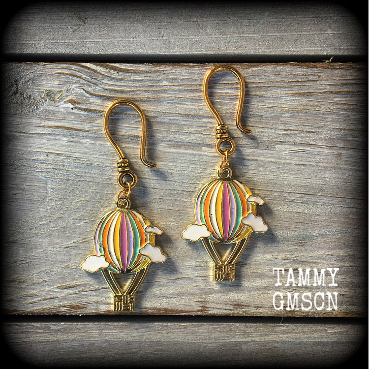 This super cute pair of earrings features antique gold and enamel hot air balloons with adorable fluffy white clouds, measuring just over 5cms from tip to tip, and weighing only a gram or two each.

This pair has been made with small antique gold shephard hooks, suitable for stretched lobes when worn through earlets from 8 gauge (3mm).