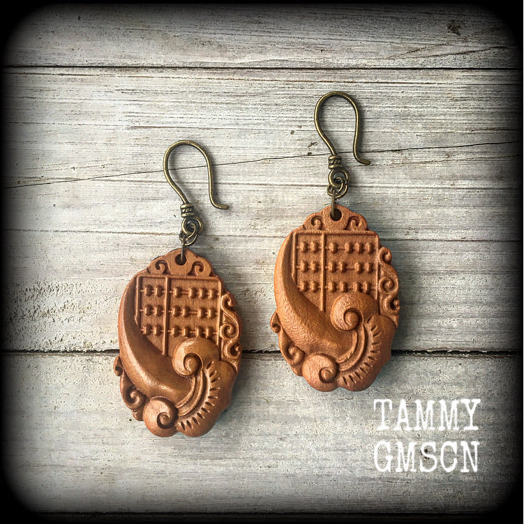 Featuring a beautiful carved wood lotus flower with traditional abacus, these lightweight earrings weigh only 6 grams each and measure spprox 6 cms from tip to tip.

This pair has been made on small antique bronze shepherd hooks, to be worn through stretched lobes in silicone earlets from 8 gauge (3mm).