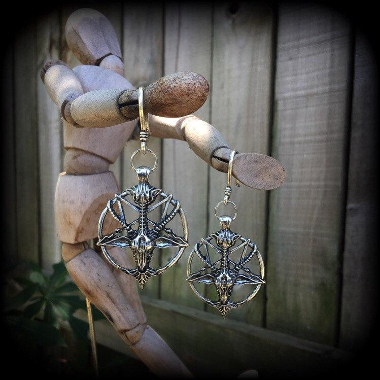 These gorgeous gothic earrings feature an antique silver Baphomet, are light weight (8 grams a piece) and nice and dangly, measuring 8cms from tip to tip.

This pair has been made on small antique silver shephards hooks to be worn through silicone earlets in stretched lobes from 8 gauge (3mm).

