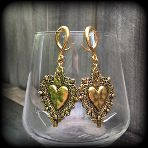 These beautiful antique gold gauged earrings feature a gorgeous antique gold milagros sacred heart, measuring just on 7cms from tip to tip, and weighing approx 7 grams each, nice and lightweight.
This pair has been made on 6 gauge (4mm) surgical steel full curl hooks, to be worn in stretched lobes.