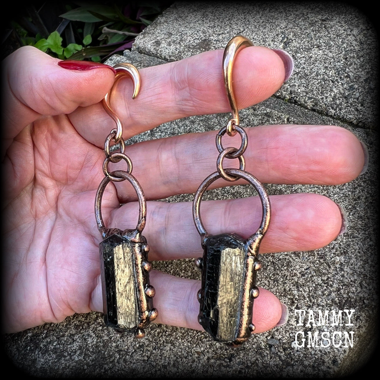 Featuring a pair of beautiful raw black tourmaline gemstones enclosed in rustic ornate copper plate detail, this pair of gorgeous gauged earrings weighs approx 16 grams a piece, and measure approx 8cms from tip to tip.

This pair have been made on 6 gauge (4mm) rose gold titanium coated surgical steel half curl hooks, suitable for stretched lobes.

