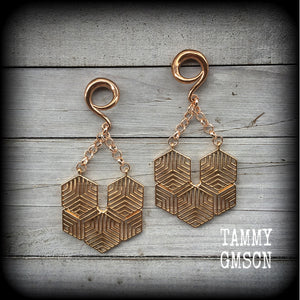 These gauged earrings feature beautiful rose gold tone geometric hexagon pendants, measuring just over 10cms from tip to tip, and weighing approx 22 grams each.
This pair has been made on 2 gauge (6mm) surgical steel full curl hooks.