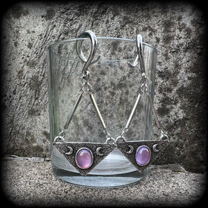 Featuring an inverted triangle with crescent moons and a single translucent purple cabachon, measuring just over 7 cms from tip to tip, and weighing approx 8 grams each.
This pair has been made on 6 gauge (4mm) surgical steel full curl hooks.