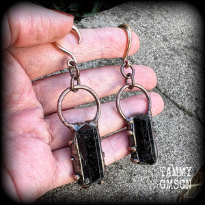 Featuring a pair of beautiful raw black tourmaline gemstones enclosed in rustic ornate copper plate detail, this pair of gorgeous gauged earrings weighs approx 16 grams a piece, and measure approx 8cms from tip to tip.

This pair have been made on 6 gauge (4mm) rose gold titanium coated surgical steel half curl hooks, suitable for stretched lobes.

