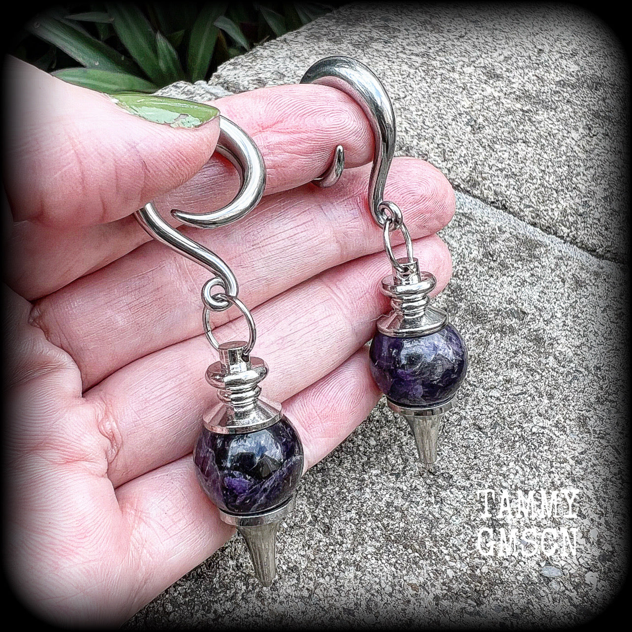 Featuring a pair of beautiful plump purple amethyst pendulums, this pair of earrings weighs approx 21 grams a piece and measure just over 7cms from tip to tip.
This pair have been made on 2 gauge (6mm) surgical steel full curl hooks, to be worn in stretched lobes.