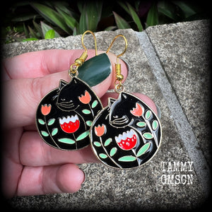 These quirky earrings and feature gorgeous folk art inspired black cat and tulip charms.
These earrings are nice and lightweight at only 4 grams, and measure just on 5cms from tip to tip.
This pair has been made with antique gold french hooks, to be worn in pierced ears.