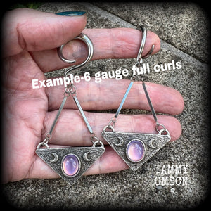 Featuring an inverted triangle with crescent moons and a single translucent purple cabachon, measuring just over 7 cms from tip to tip, and weighing approx 8 grams each.
This pair has been made on 6 gauge (4mm) surgical steel full curl hooks.
