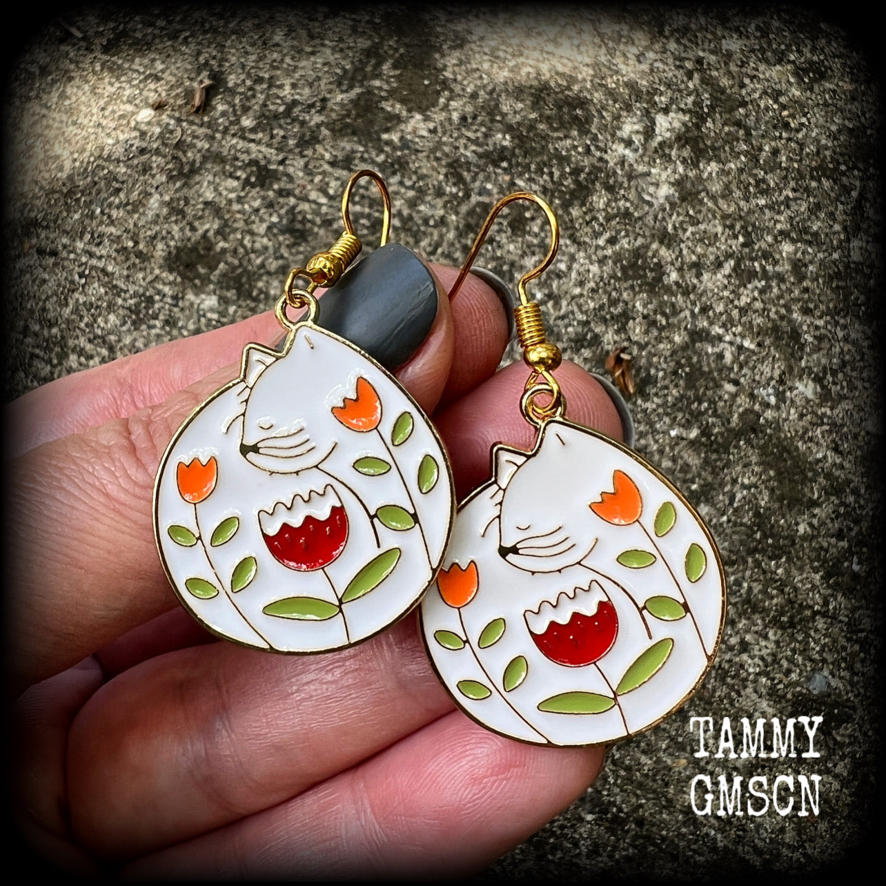 These adorably quirky earrings feature gorgeous folk art inspired cat and tulip charms.
Measuring 5cms from tip to tip, these earrings are nice and lightweight at only 4 grams each.
This pair has been made on antique gold french hooks, to be worn in pierced ears.