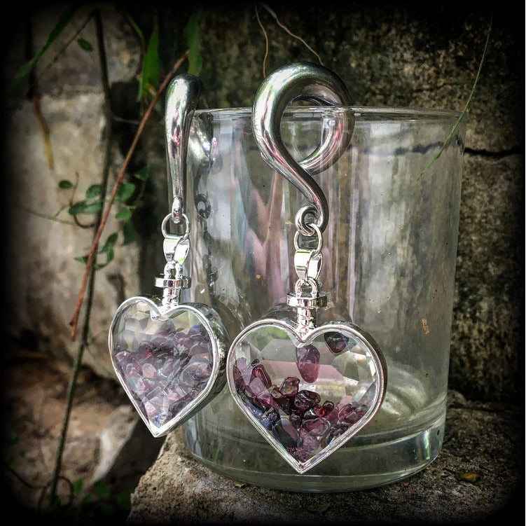 Heart shaped glass bottles filled with garnet gemstone chips, available on a range of hooks and clasps for pierced ears and stretched lobes.