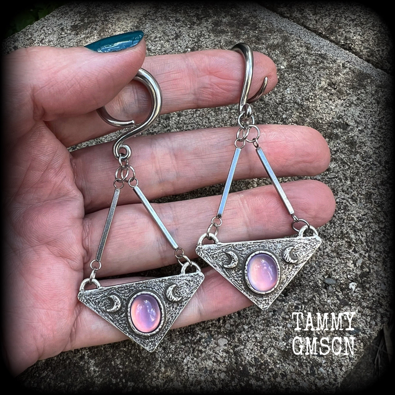 Featuring an inverted triangle with crescent moons and a single translucent purple cabachon, measuring just over 7 cms from tip to tip, and weighing approx 8 grams each.
This pair has been made on 6 gauge (4mm) surgical steel full curl hooks.