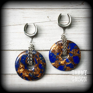 Featuring a pair of gorgeous dark blue lapis lazuli and bronzite donut gemstones cradles in stainless steel chain, this pair of ear hangers weigh approx 34 grams a piece, and measure just under 10cms from tip to tip.

This pair have been made on 7/8" (22mm) gauge surgical steel cradles, for stretched lobes.
