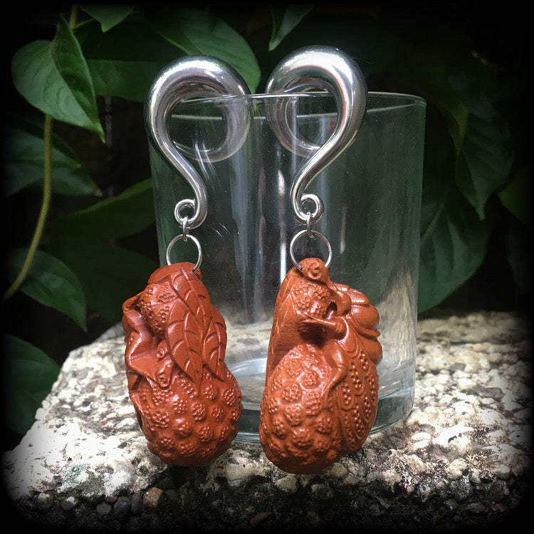 These beautiful gauged earrings feature a carved peach wood cicada, weighing in at 32 grams a piece, and measuring just under 10cms from tip to tip.
This pair has been made on 00 gauge (10mm) surgical steel full curl hooks, for stretched lobes.
