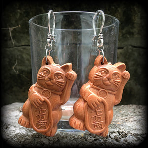 These earrings feature carved rose wood Maneki Neko cats, measure 8cms from tip to tip, and weigh approx 8 grams each.
These are made on small antique silver shephard hooks, for stretched lobes when worn with silicone earlets from 8 gauge (3mm). 