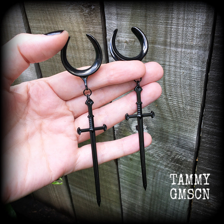 These gorgeous ear hangers feature a pitch black enamel sword pendant, measuring just on 12cms from tip to tip, and weighing approx 12 grams each.
This pair has been made on 1" (25mm) surgical steel cradle hooks, to be worn in stretched lobes.