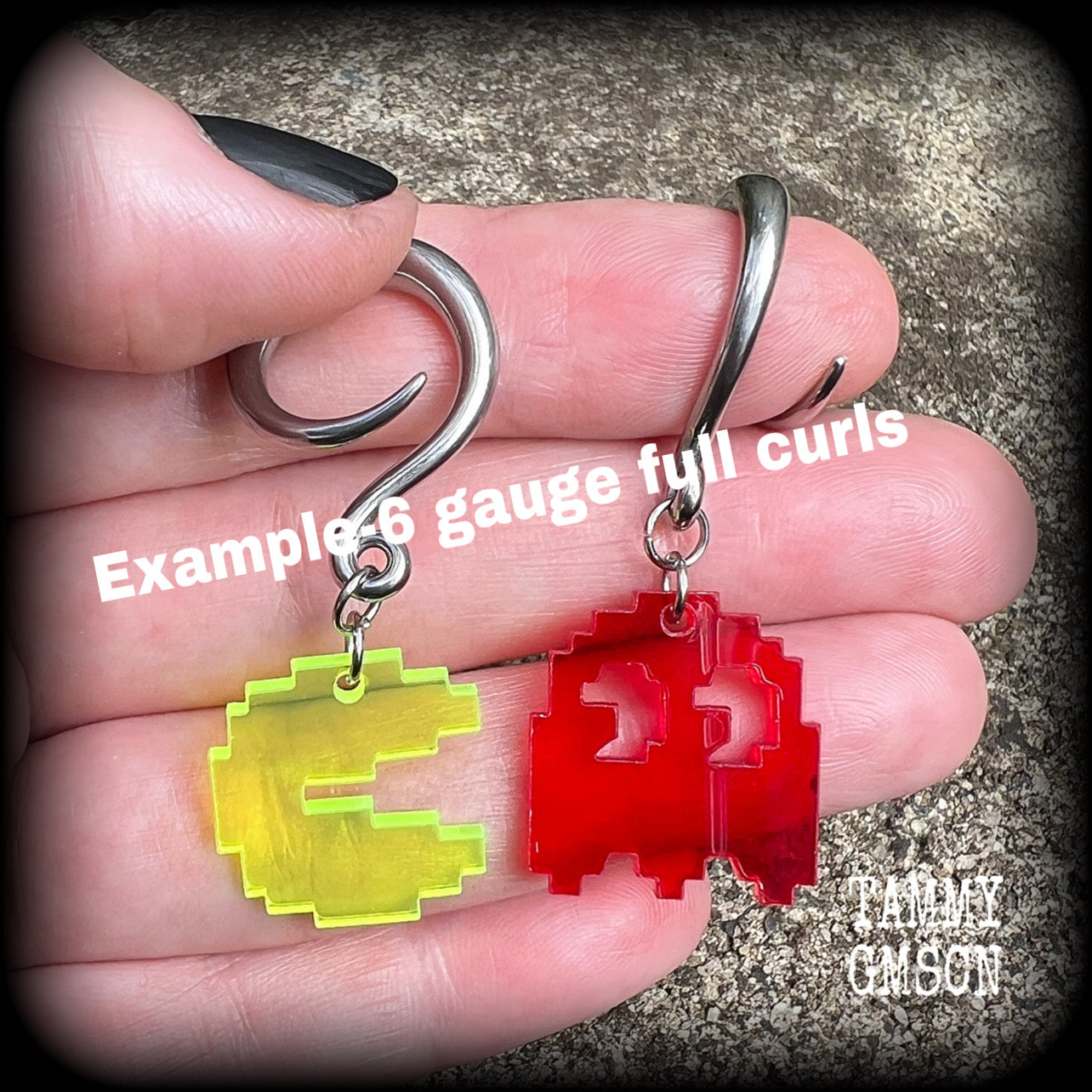 These super rad earrings feature classic acrylic pixelated Pac man and Blinky charms, measuring 5 cms from tip to tip, weighing in at only 4 grams each.
This pair has been made on 6 gauge (4mm) surgical steel full curl hooks, suitable for stretched lobes.