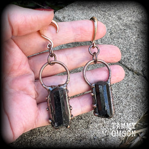 Featuring a pair of beautiful raw black tourmaline gemstones enclosed in rustic ornate copper plate detail, this pair of gorgeous gauged earrings weighs approx 16 grams a piece, and measure approx 8cms from tip to tip.

This pair have been made on 6 gauge (4mm) rose gold titanium coated surgical steel half curl hooks, suitable for stretched lobes.

