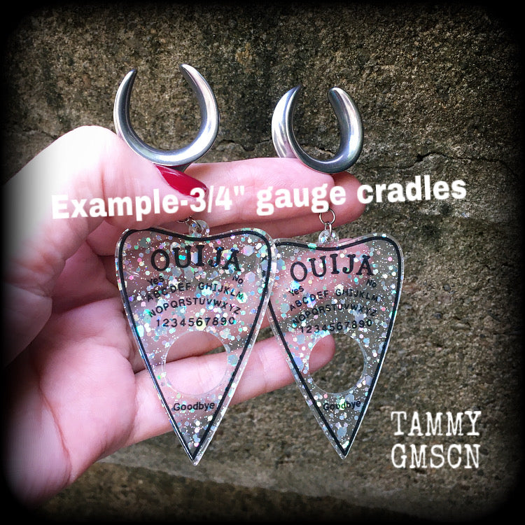Featuring large glittery acrylic ouija board planchettes, this pair of gorgeous earrings weighs approx 10 grams a piece, and measure 10cms from tip to tip.

This pair has been made with 3/4" gauge (19mm) surgical steel cradle hooks, for stretched lobes.