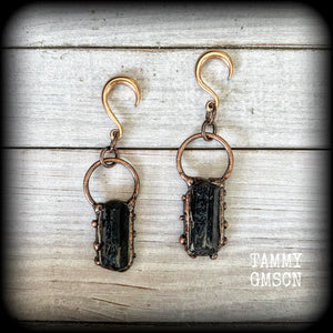 Featuring a pair of beautiful raw black tourmaline gemstones enclosed in rustic ornate copper plate detail, this pair of gorgeous gauged earrings weighs approx 16 grams a piece, and measure approx 8cms from tip to tip.

This pair have been made on 6 gauge (4mm) rose gold titanium coated surgical steel half curl hooks, suitable for stretched lobes.

