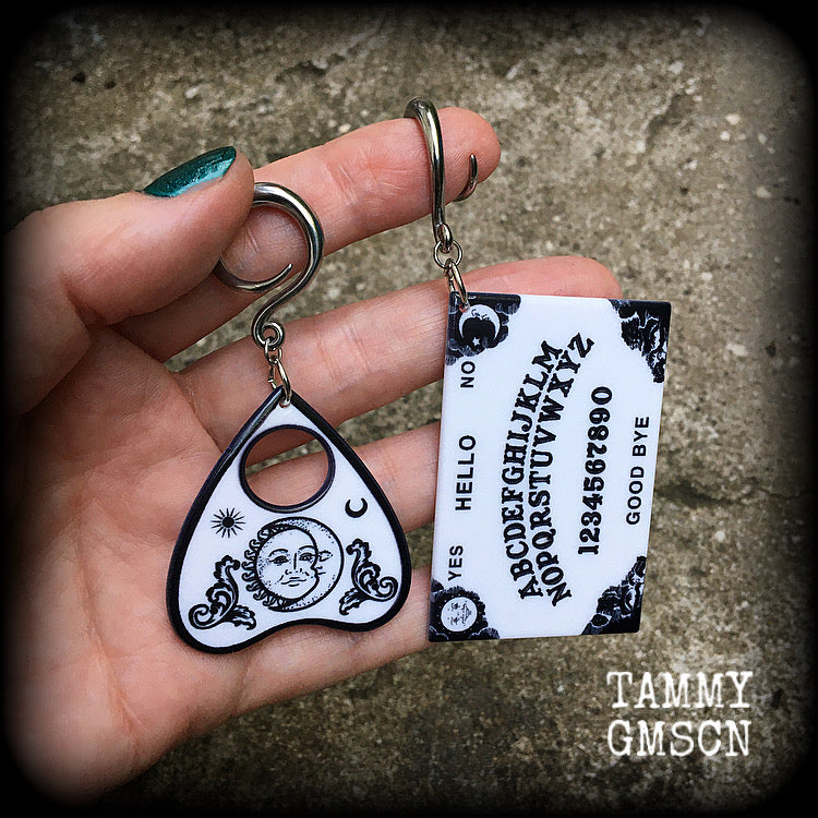These spooky cute earrings feature black and white double sided acrylic ouija board and planchette charms, weighing approx 7 grams a piece, and measuring 7-9cms from tip to tip.

These have been made on 6 gauge (4mm) surgical steel full curl hooks, to be worn in stretched lobes.