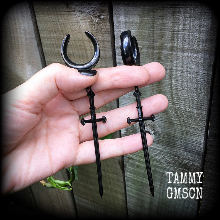 These gorgeous ear hangers feature a pitch black enamel sword pendant, measuring just on 12cms from tip to tip, and weighing approx 12 grams each.
This pair has been made on 1" (25mm) surgical steel cradle hooks, to be worn in stretched lobes.