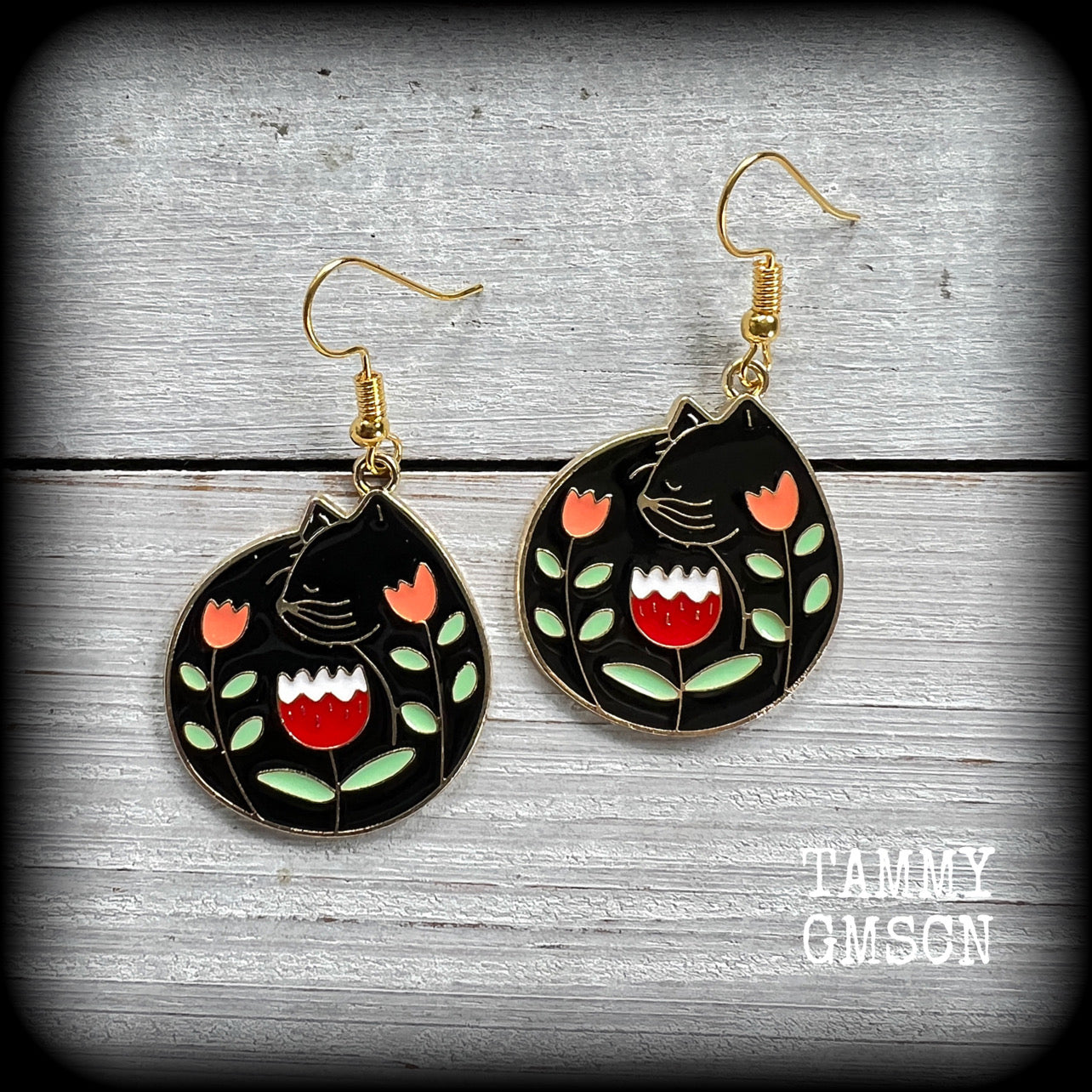 These quirky earrings and feature gorgeous folk art inspired black cat and tulip charms.
These earrings are nice and lightweight at only 4 grams, and measure just on 5cms from tip to tip.
This pair has been made with antique gold french hooks, to be worn in pierced ears.