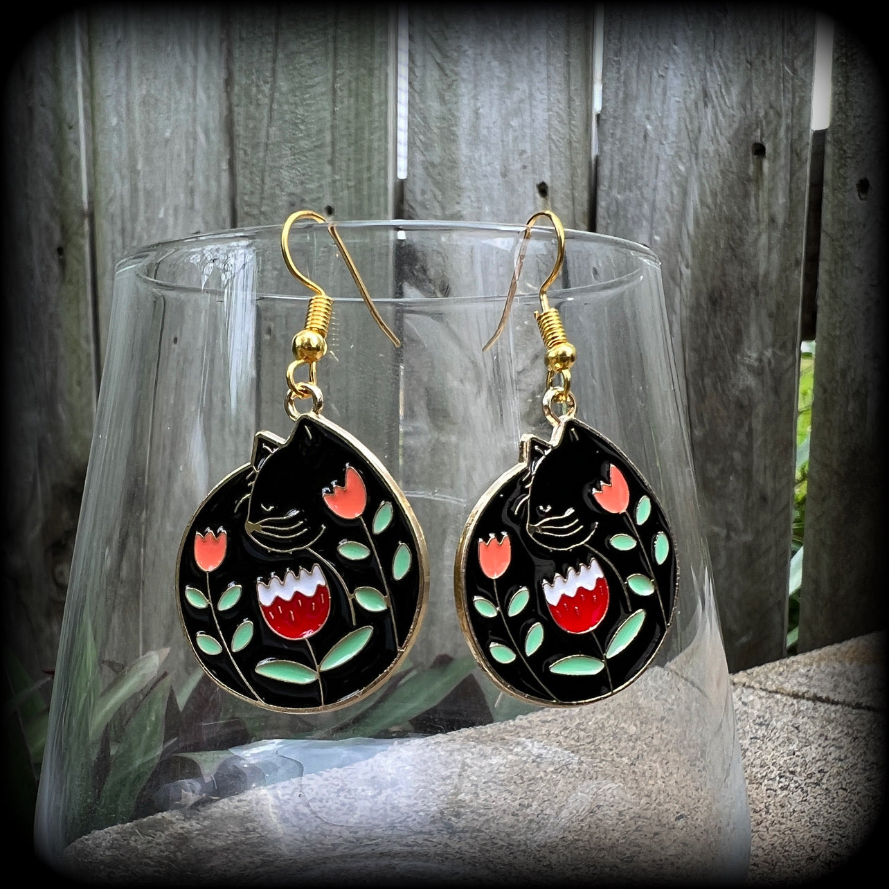 These quirky earrings and feature gorgeous folk art inspired black cat and tulip charms.
These earrings are nice and lightweight at only 4 grams, and measure just on 5cms from tip to tip.
This pair has been made with antique gold french hooks, to be worn in pierced ears.