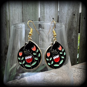 These quirky earrings and feature gorgeous folk art inspired black cat and tulip charms.
These earrings are nice and lightweight at only 4 grams, and measure just on 5cms from tip to tip.
This pair has been made with antique gold french hooks, to be worn in pierced ears.