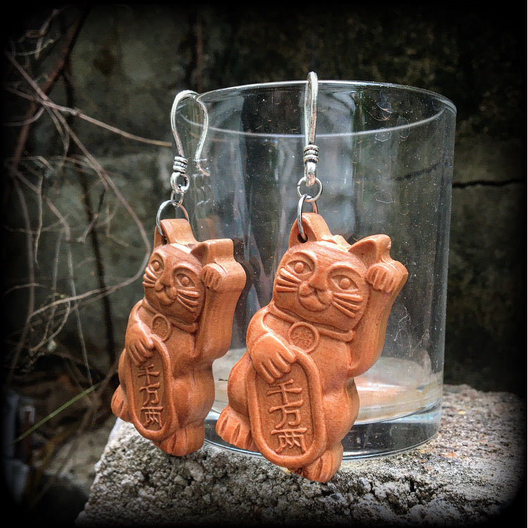 These earrings feature carved rose wood Maneki Neko cats, measure 8cms from tip to tip, and weigh approx 8 grams each.
These are made on small antique silver shephard hooks, for stretched lobes when worn with silicone earlets from 8 gauge (3mm). 