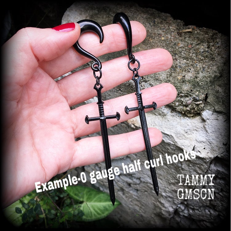 These gorgeous ear hangers feature a pitch black enamel sword pendant, measuring just on 12cms from tip to tip, and weighing approx 12 grams each.
This pair has been made on 0 gauge half curl hooks