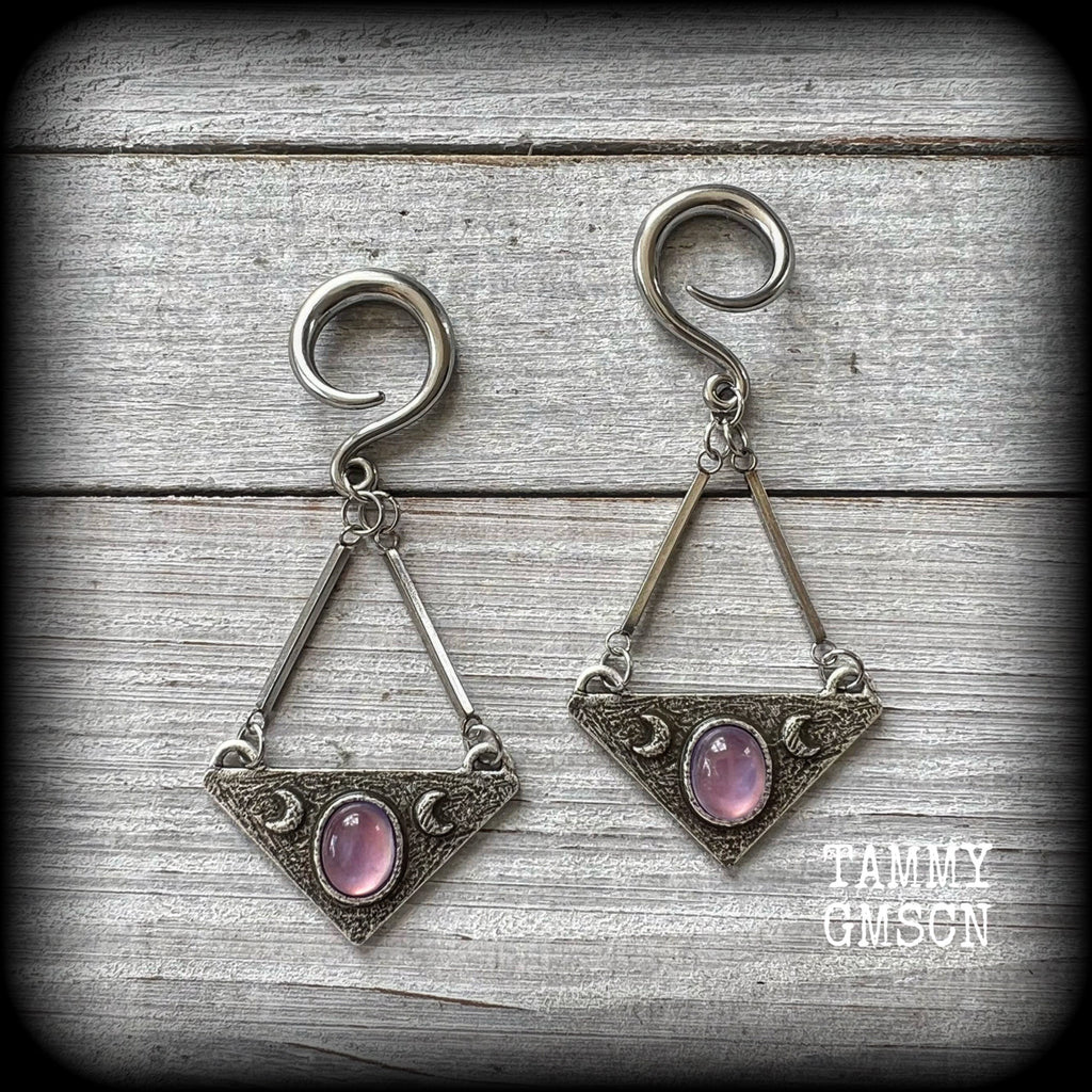 Featuring an inverted triangle with crescent moons and a single translucent purple cabachon, measuring just over 7 cms from tip to tip, and weighing approx 8 grams each.
This pair has been made on 6 gauge (4mm) surgical steel full curl hooks.