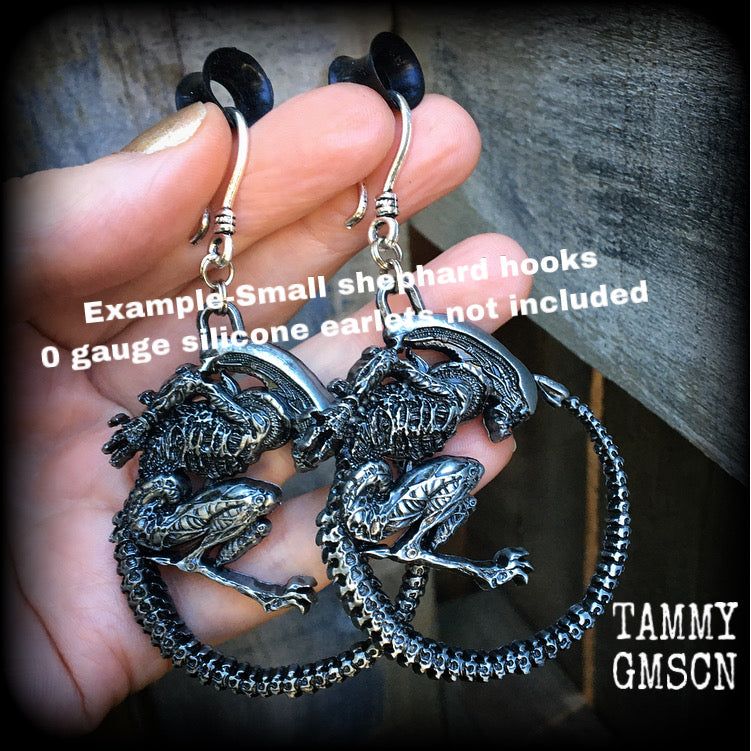 These awesome earrings feature a pair of large pewter Alien Queen Xenomorphs, measuring 9cms from tip to tip (nice and big), and weigh 38 grams each (these are HEAVY).

This pair have been made on small antique silver shephard hooks to be worn in stretched lobes with silicone earlets from 8 gauge (3mm).