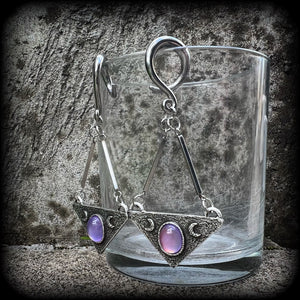 Featuring an inverted triangle with crescent moons and a single translucent purple cabachon, measuring just over 7 cms from tip to tip, and weighing approx 8 grams each.
This pair has been made on 6 gauge (4mm) surgical steel full curl hooks.