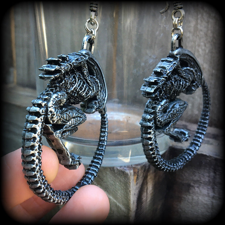 These awesome earrings feature a pair of large pewter Alien Queen Xenomorphs, measuring 9cms from tip to tip (nice and big), and weigh 38 grams each (these are HEAVY).

This pair have been made on small antique silver shephard hooks to be worn in stretched lobes with silicone earlets from 8 gauge (3mm).