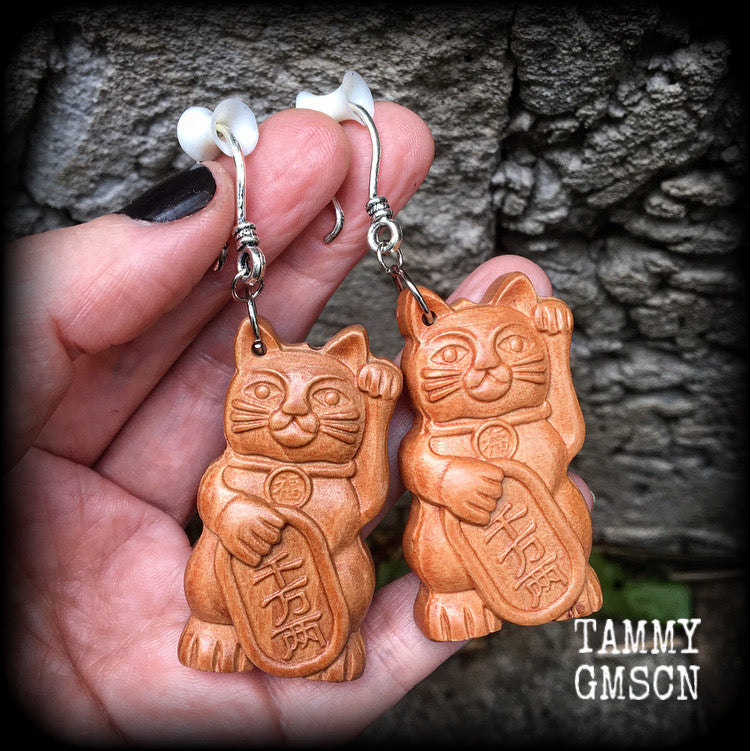 These earrings feature carved rose wood Maneki Neko cats, measure 8cms from tip to tip, and weigh approx 8 grams each.
These are made on small antique silver shephard hooks, for stretched lobes when worn with silicone earlets from 8 gauge (3mm). 