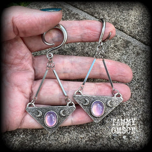 Featuring an inverted triangle with crescent moons and a single translucent purple cabachon, measuring just over 7 cms from tip to tip, and weighing approx 8 grams each.
This pair has been made on 6 gauge (4mm) surgical steel full curl hooks.