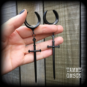 These gorgeous ear hangers feature a pitch black enamel sword pendant, measuring just on 12cms from tip to tip, and weighing approx 12 grams each.
This pair has been made on 1" (25mm) surgical steel cradle hooks, to be worn in stretched lobes.