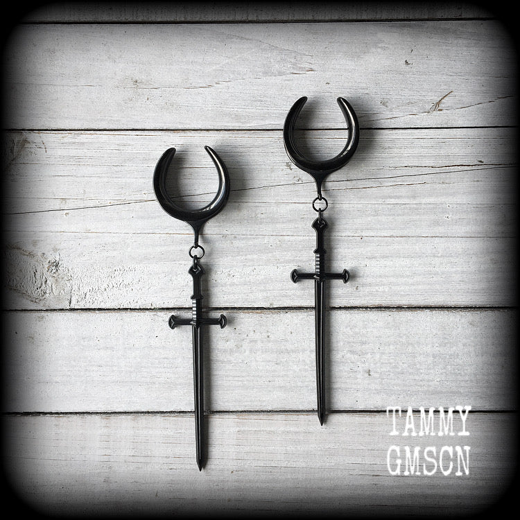 These gorgeous ear hangers feature a pitch black enamel sword pendant, measuring just on 12cms from tip to tip, and weighing approx 12 grams each.
This pair has been made on 1" (25mm) surgical steel cradle hooks, to be worn in stretched lobes.